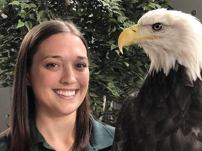 Dr. Victoria Hall posing with a bald eagle