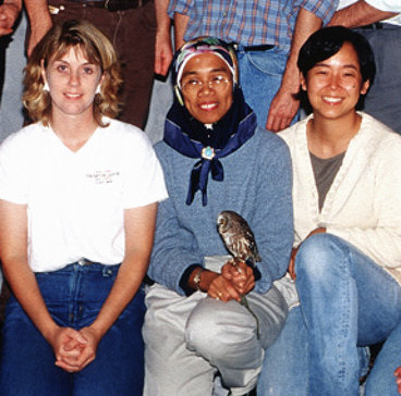 Dr. Jalila Abu holding a bird and surrounded by colleagues